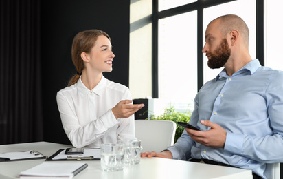 Photo of Business people talking at white table in conference room