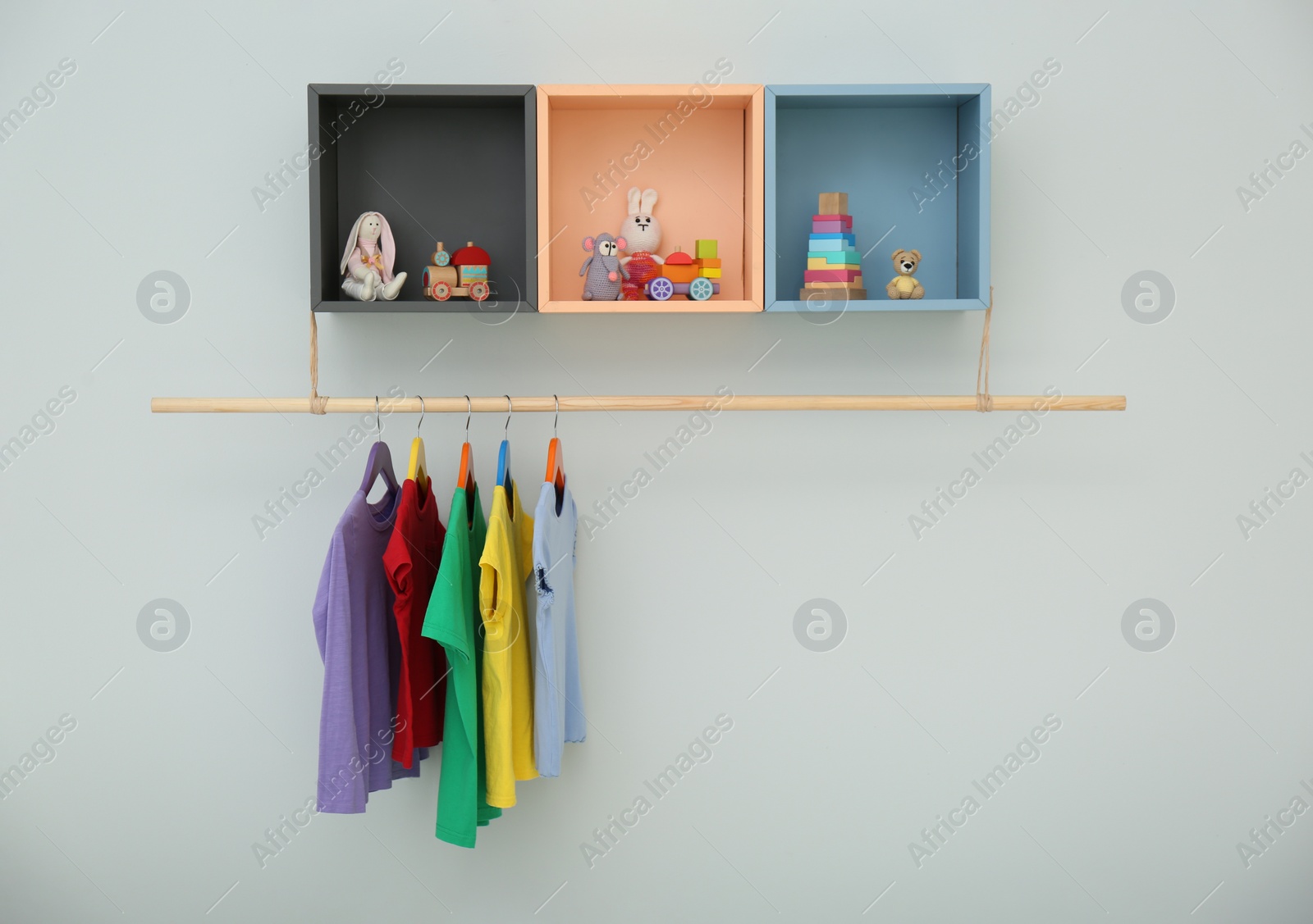 Photo of Rack with different clothes on light background