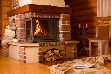 Photo of Fireplace with burning wood in room. Winter vacation