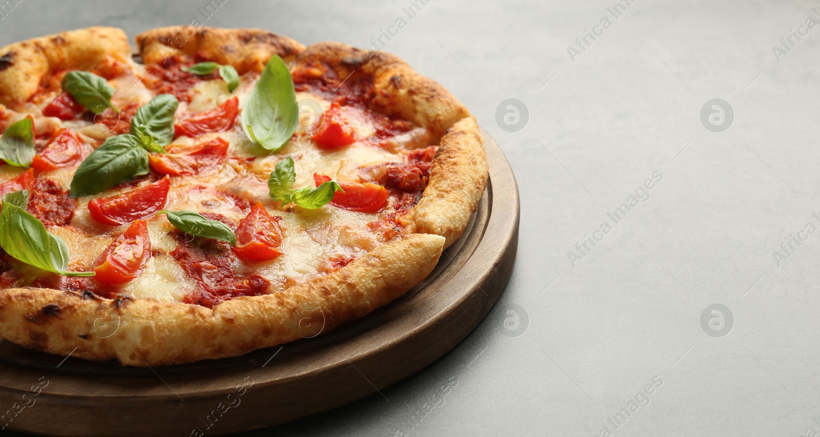 Photo of Delicious Margherita pizza on grey table, closeup. Space for text