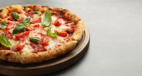 Delicious Margherita pizza on grey table, closeup. Space for text