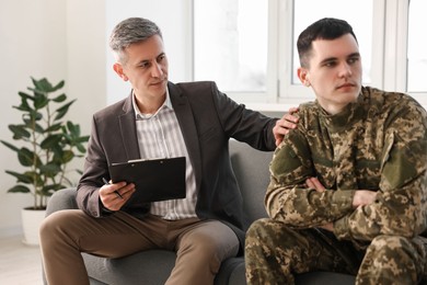 Professional psychotherapist working with military man in office