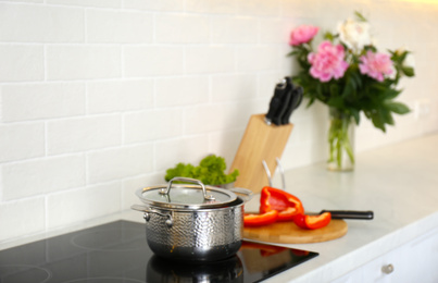 Photo of New saucepot on induction stove in kitchen