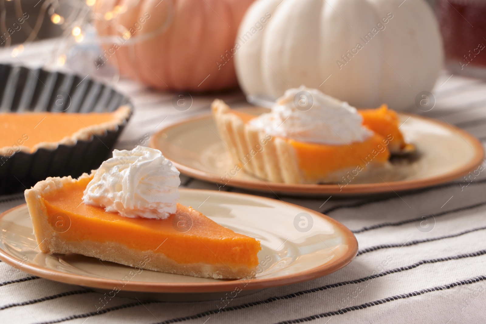 Photo of Fresh homemade pumpkin pie with whipped cream on table