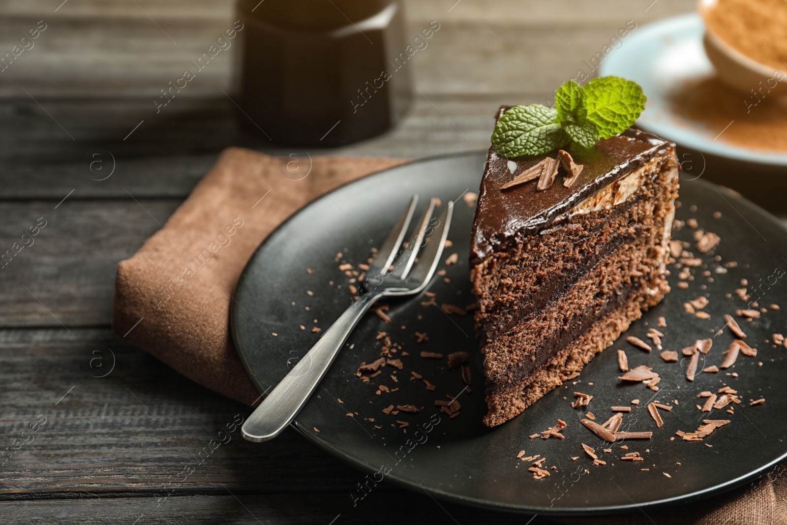 Photo of Plate with slice of chocolate cake and fork on table