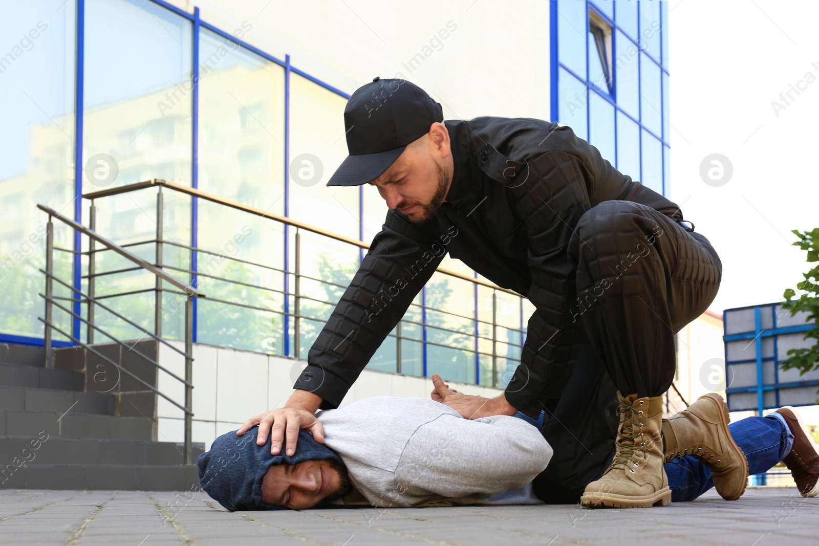 Photo of Police officer arresting dangerous criminal on street