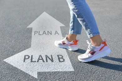 Image of Choosing between Plan A and Plan B. Woman near pointers on road, closeup view