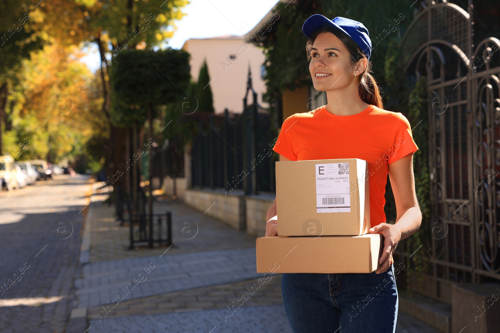 Photo of Courier carrying cardboard boxes on city street