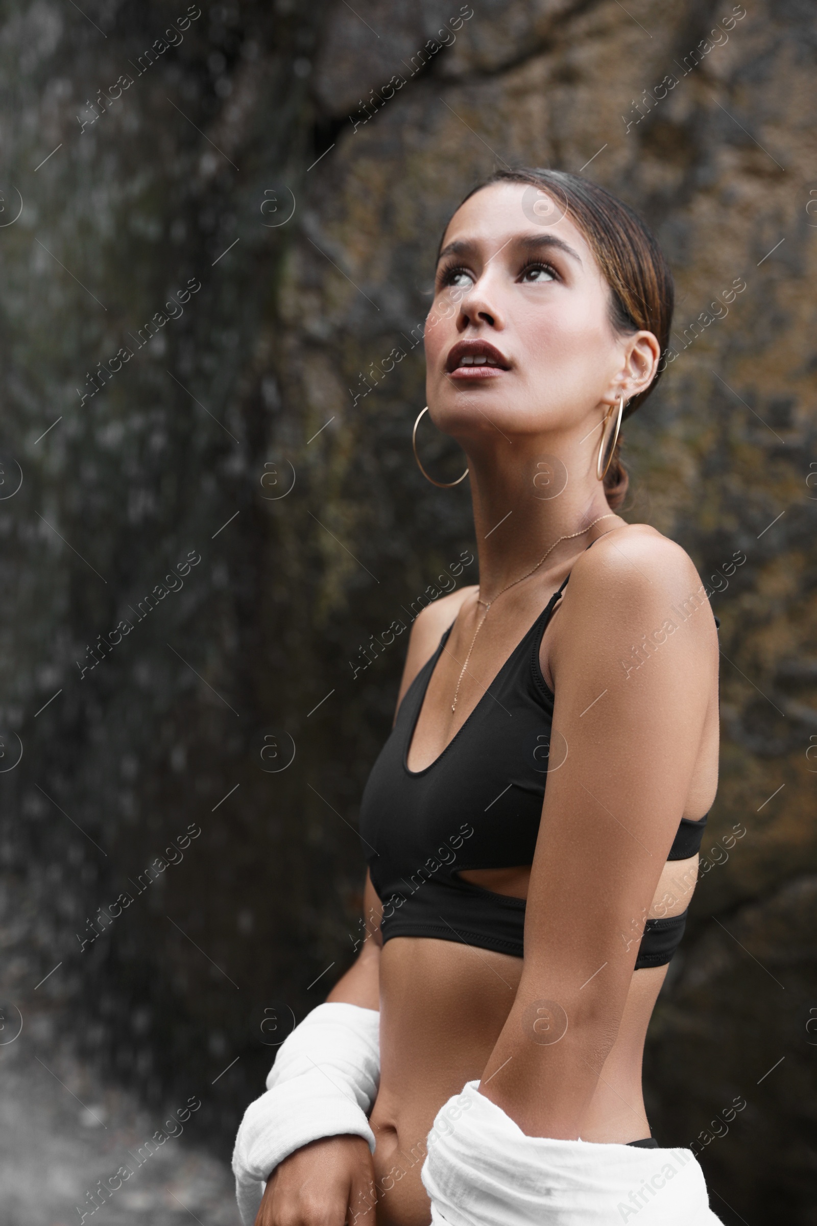 Photo of Beautiful young woman in stylish bikini near waterfall outdoors