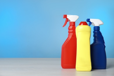 Photo of Different cleaning products on light table. Space for text