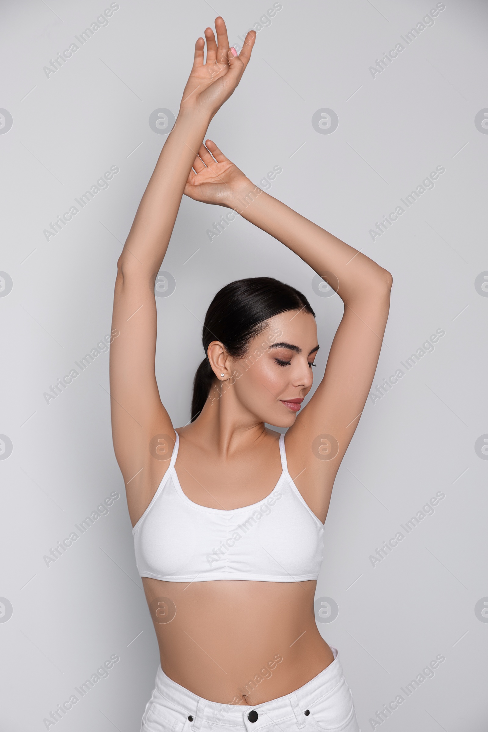 Photo of Young woman showing smooth skin after epilation on white background