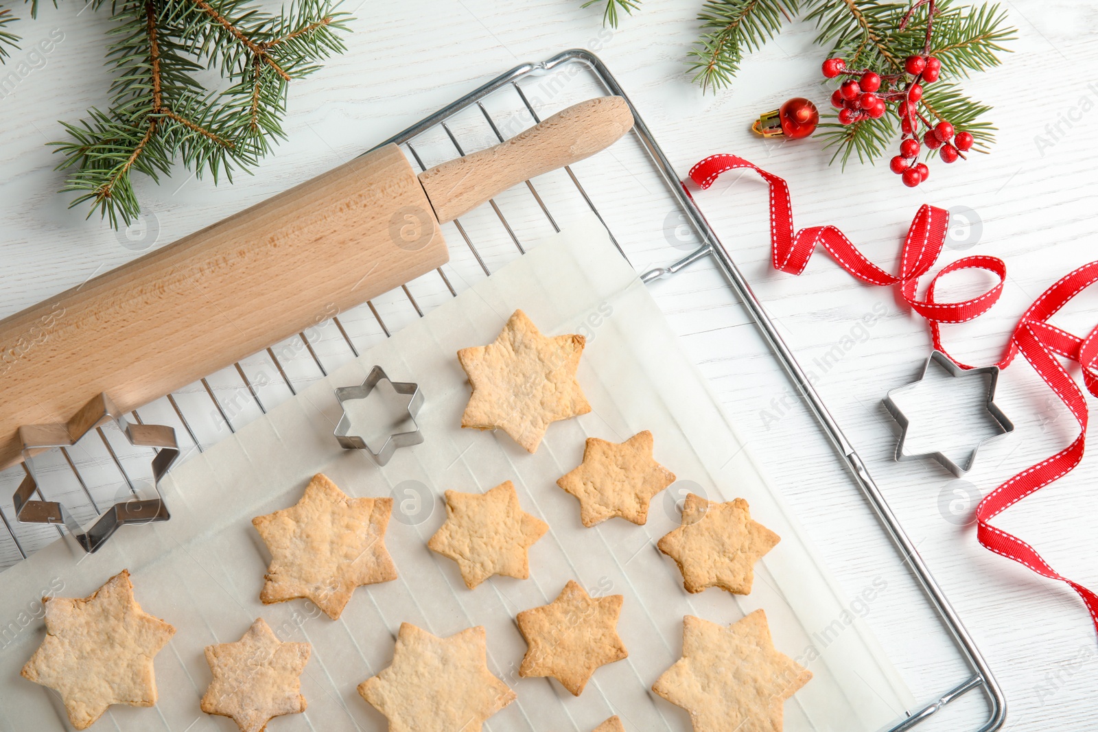 Photo of Tasty homemade Christmas cookies on baking parchment, top view