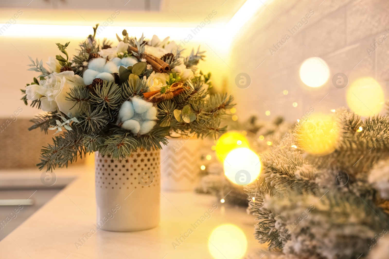 Photo of Beautiful winter bouquet and fir tree branches on white table indoors