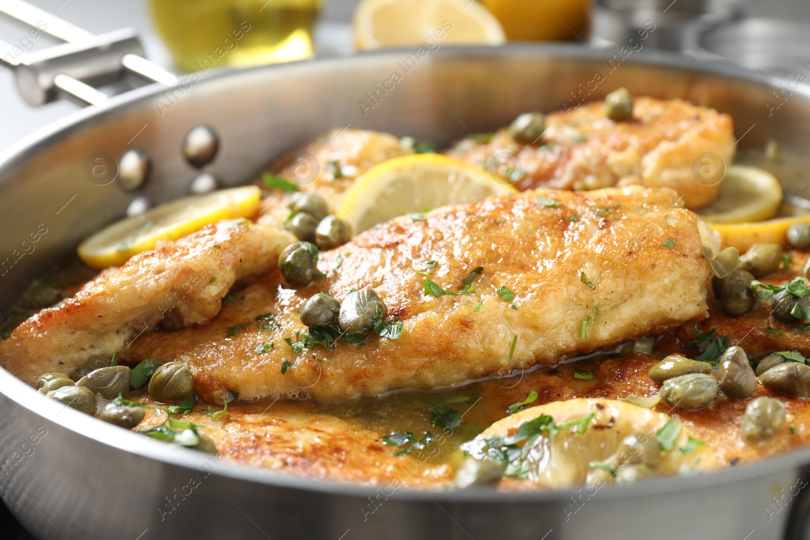 Photo of Delicious chicken piccata with herbs on table, closeup