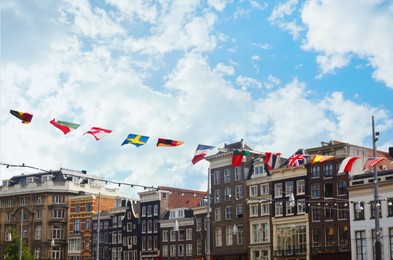 Modern buildings and rope with country flags outdoors