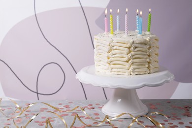 Delicious cake with cream and burning candles on grey table. Space for text