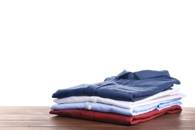 Photo of Pile of ironed clothes on table against white background