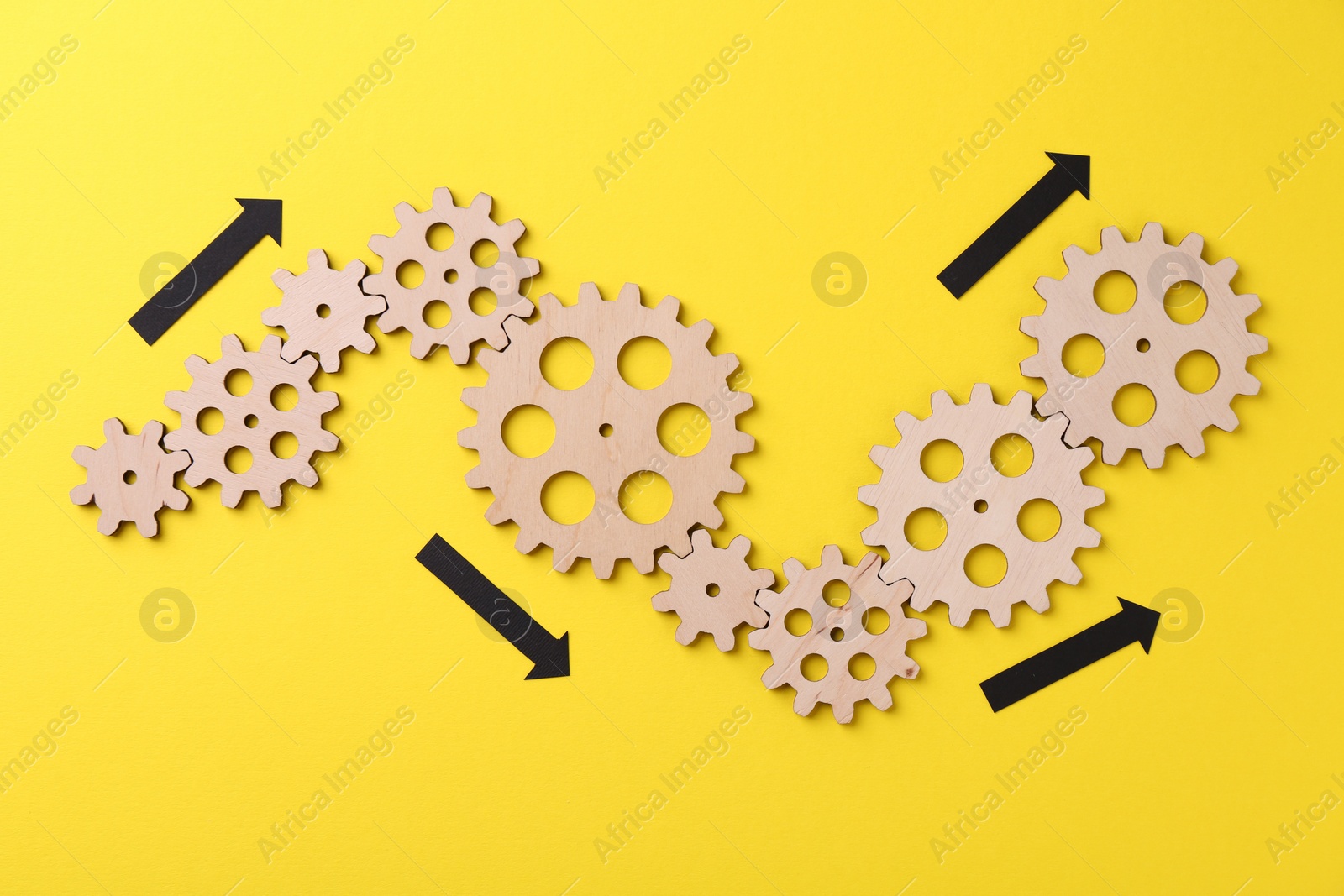 Photo of Business process organization and optimization. Scheme with wooden figures and arrows on yellow background, top view