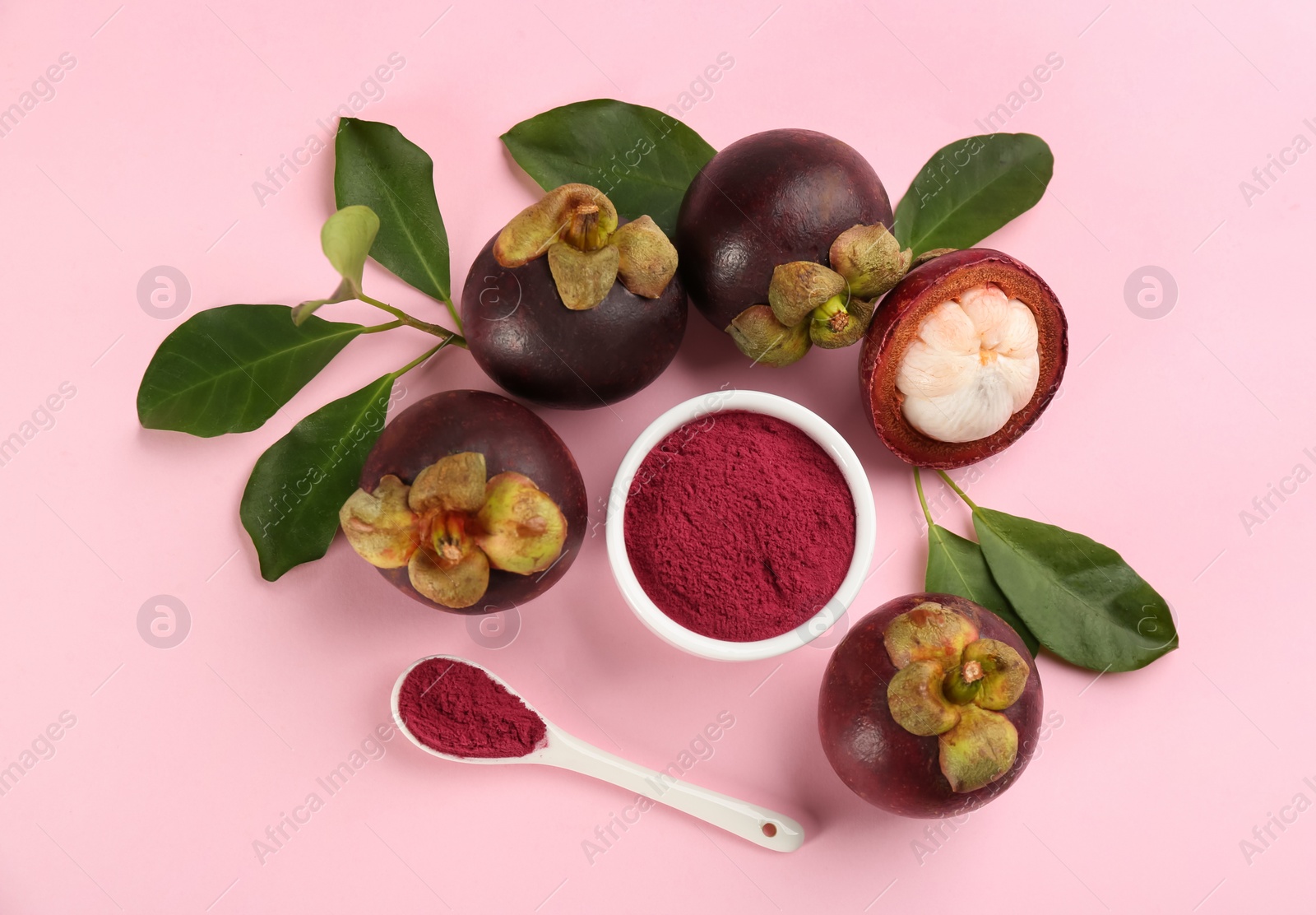 Photo of Purple mangosteen powder and fruits on pink background, flat lay