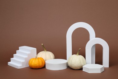 Autumn presentation for product. White geometric figures and pumpkins on brown background