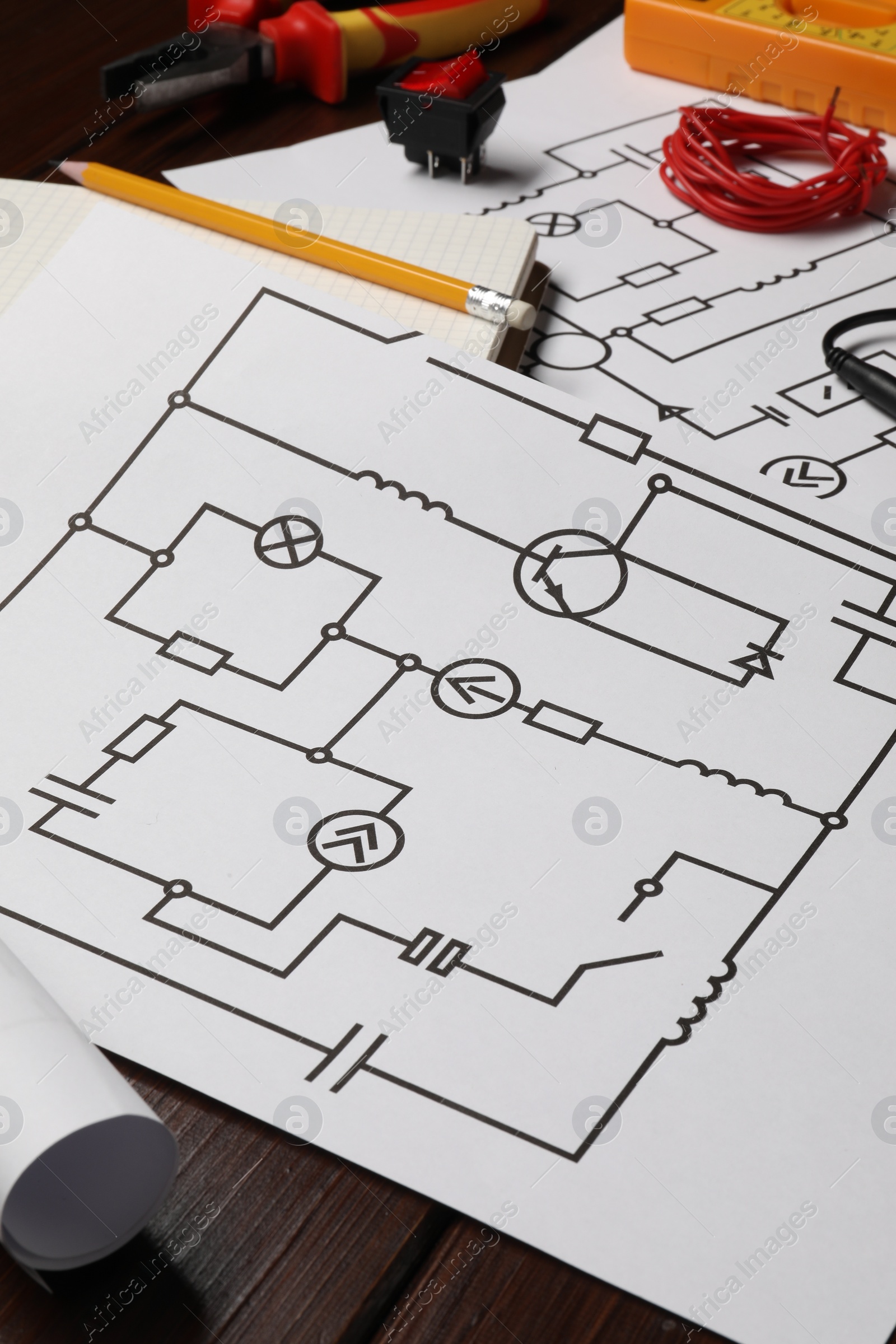 Photo of Wiring diagrams and different electrician's equipment on wooden table