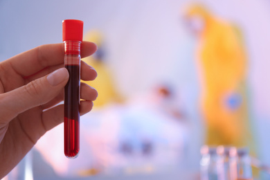 Photo of Closeup view of paramedic holding test tube with sample of virus in quarantine ward, space for text