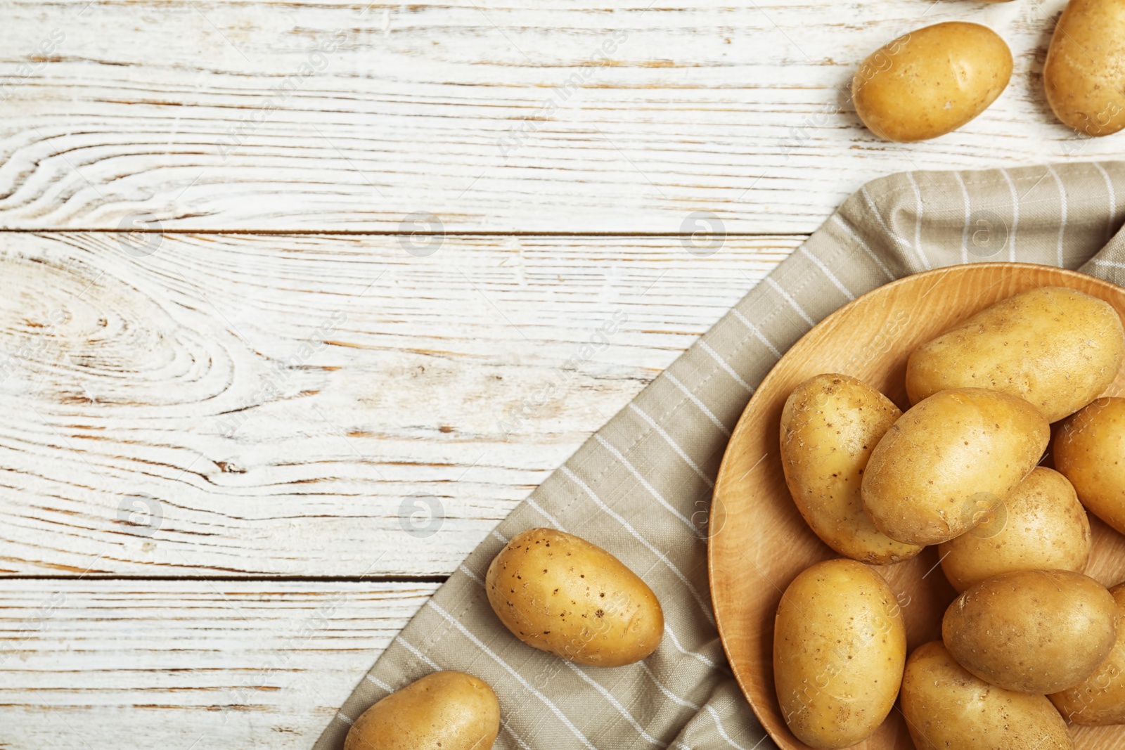 Photo of Fresh ripe organic potatoes on wooden background, top view