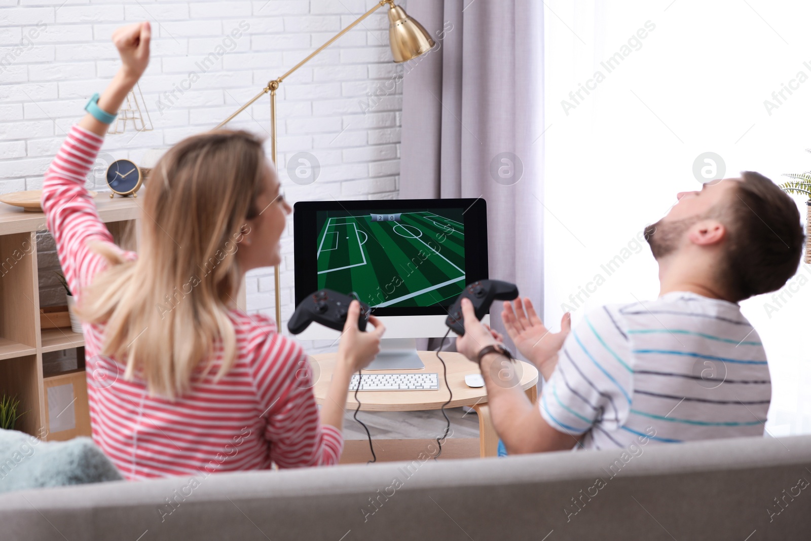 Photo of Young couple playing video game at home