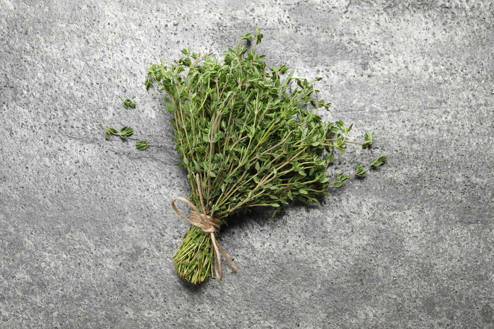 Photo of Bunch of aromatic thyme on grey table, top view