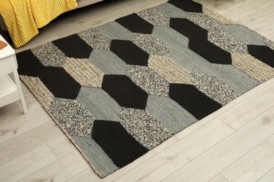 Carpet with geometric pattern on wooden floor in room