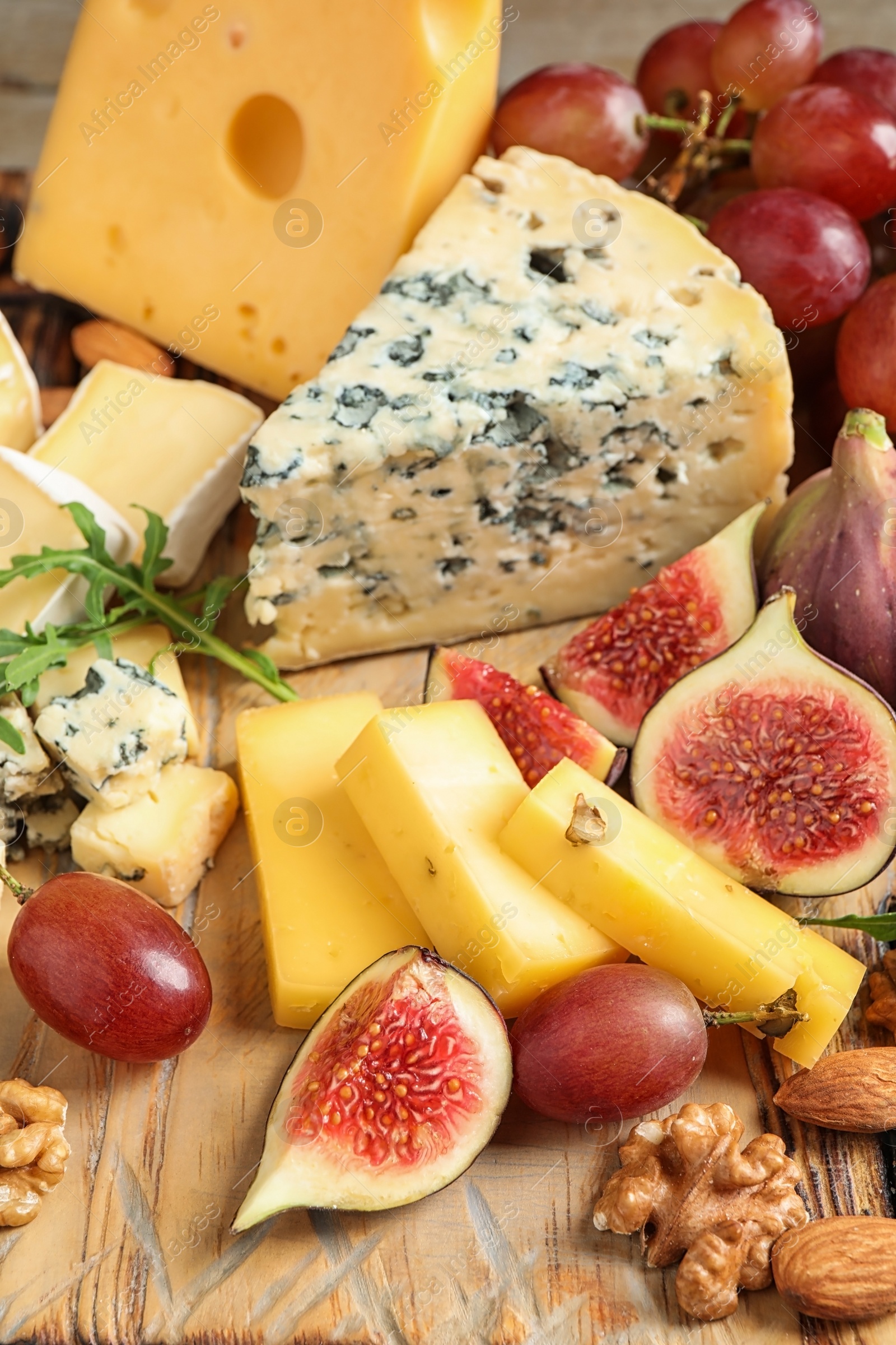 Photo of Set of different snacks with ripe figs served on wooden table, closeup