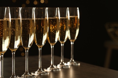 Photo of Many glasses of champagne on table. Space for text