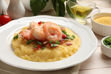 Photo of Plate with fresh tasty shrimps, bacon, grits, green onion and pepper on wooden table, closeup