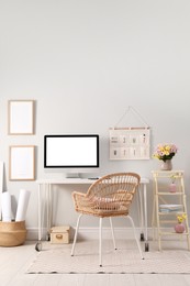 Photo of Comfortable workplace with modern computer and flowers in room. Interior design
