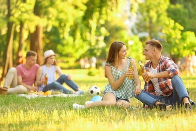 Photo of Young people enjoying picnic in park on summer day