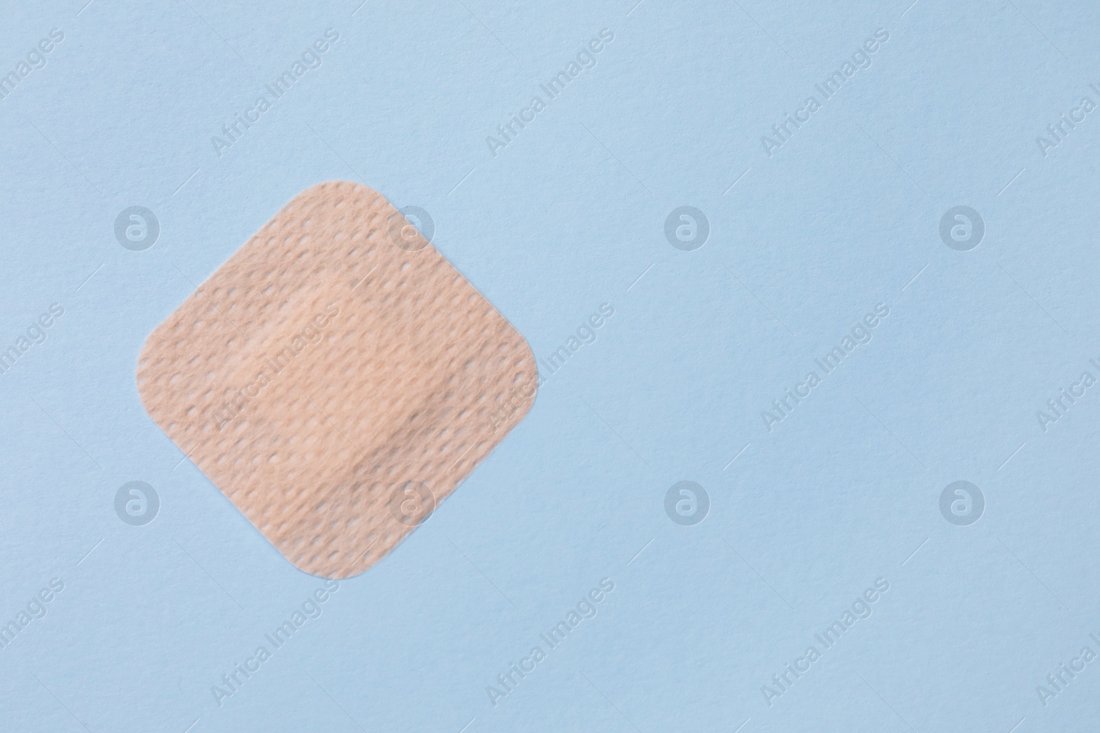 Photo of Contraceptive patch on light blue background, top view. Space for text