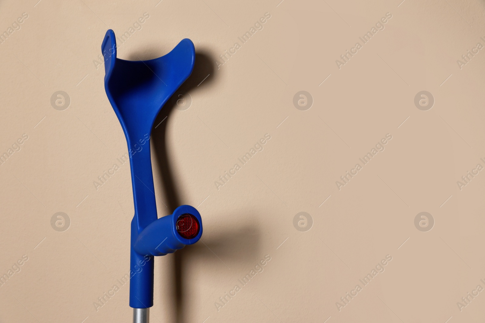 Photo of Elbow crutch on beige background. Space for text