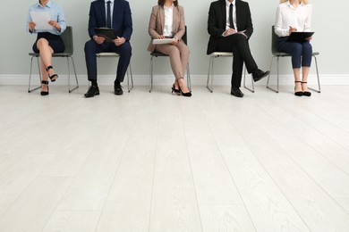 Photo of People waiting for job interview in office hall, closeup