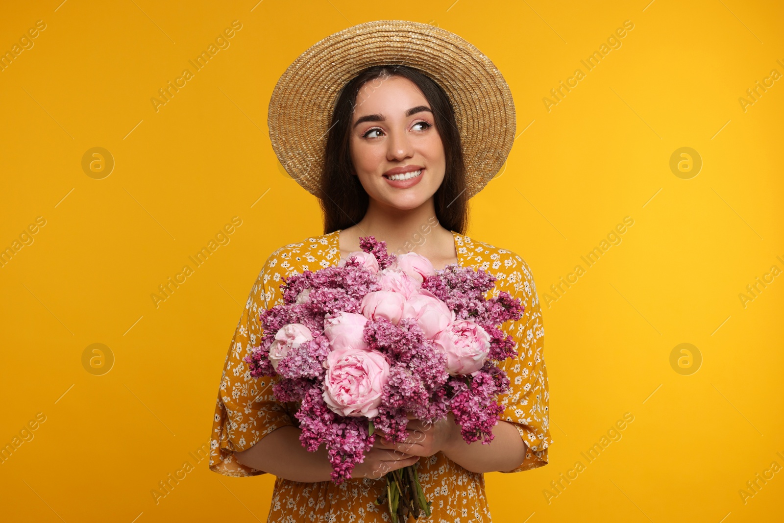 Photo of Beautiful woman with bouquet of spring flowers on yellow background