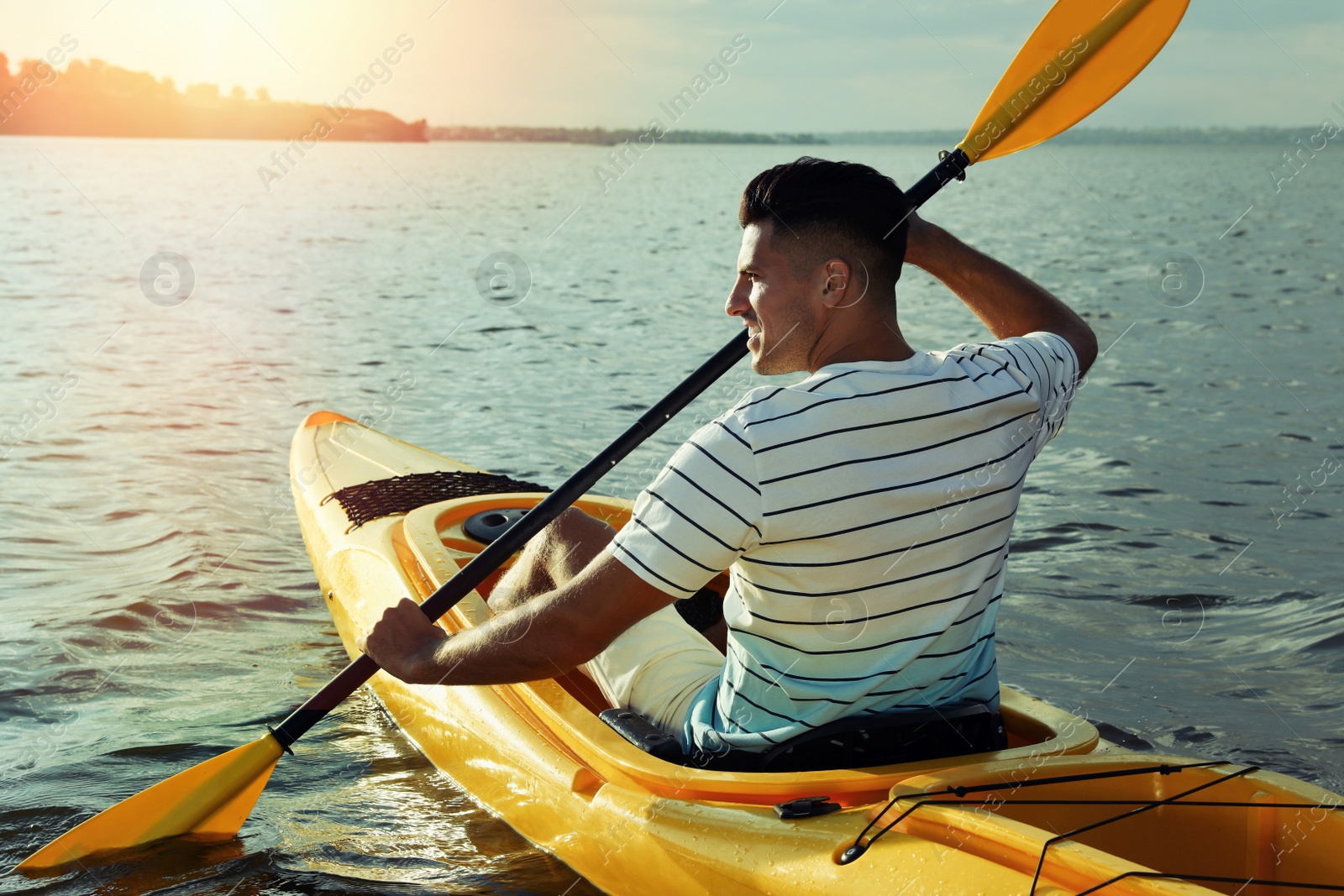 Photo of Happy man kayaking on river, back view. Summer activity