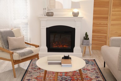 Beautiful fireplace, armchair and table in living room. Interior design