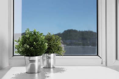 Artificial potted herbs on sunny day on windowsill indoors, space for text. Home decor