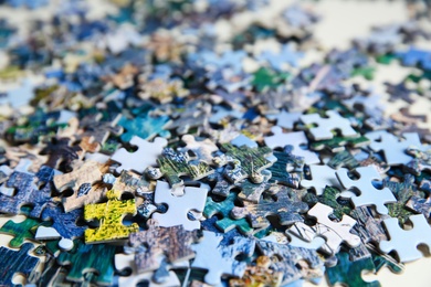 Photo of Jigsaw puzzle pieces on table, closeup view
