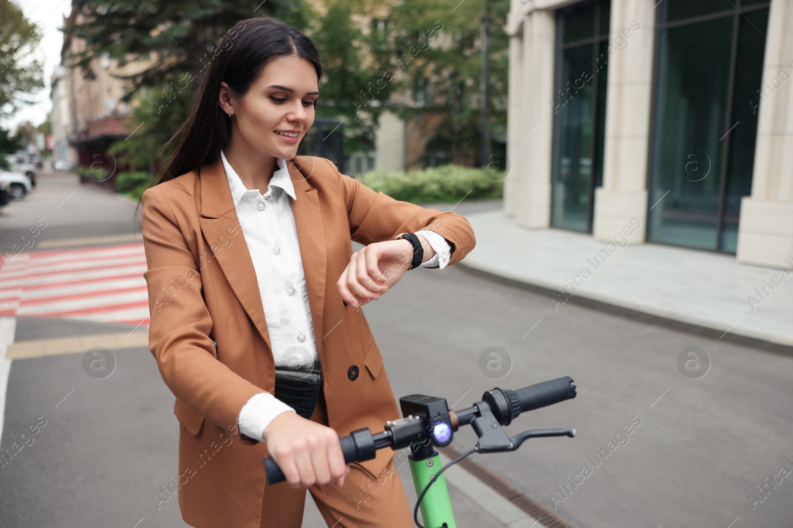 Photo of Businesswoman with modern electric kick scooter on city street, space for text