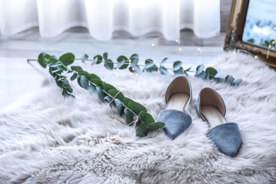 Elegant female shoes on fluffy carpet