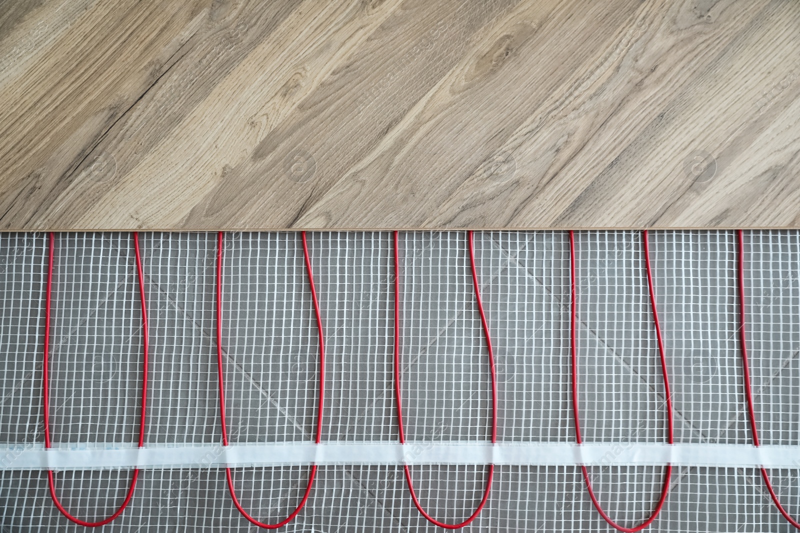 Photo of Installation of modern underfloor trace heating system indoors, top view