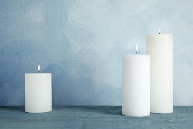 Alight wax candles on table. Space for text