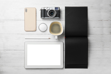 Photo of Flat lay composition with vintage camera, tablet and smartphone on white wooden table. Designer's workplace