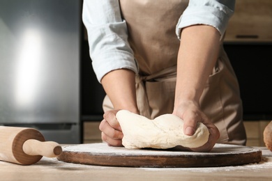 Photo of Female baker preparing bread dough at table, closeup