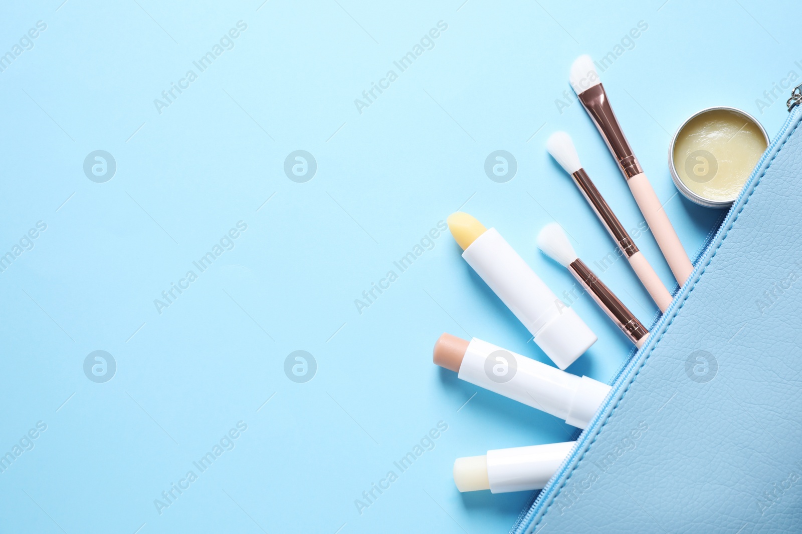 Photo of Flat lay composition with hygienic lipsticks on light blue background, space for text